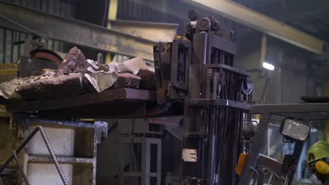 forklift with large blocks of scrap metal waste