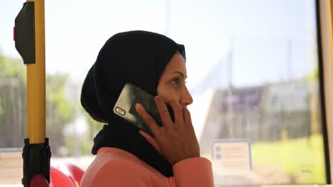 mujer joven con hijab viajando en un autobús