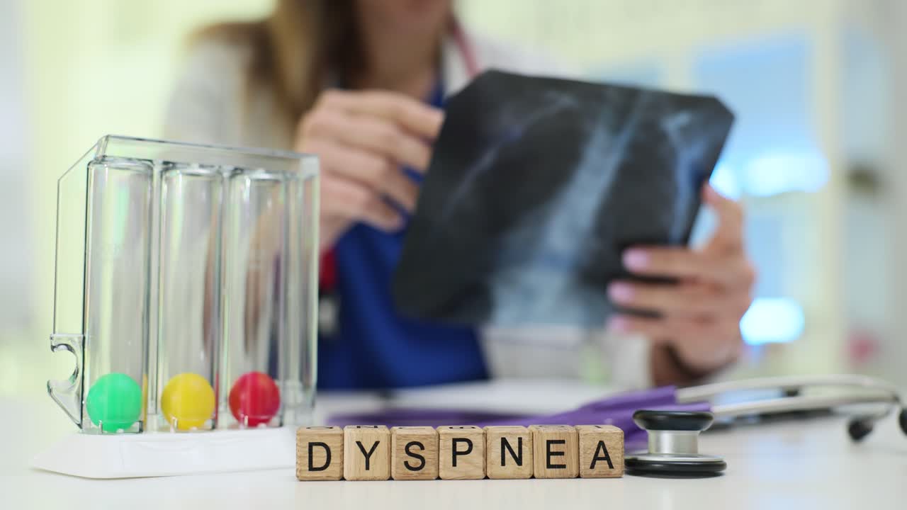 Balok kayu mengeja 'dispnea' saat dokter meninjau film rontgen paru-paru