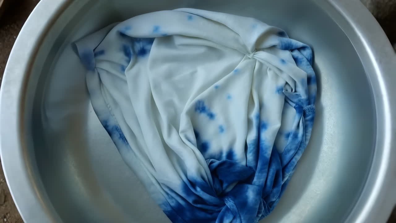 Tie-dye fabric soaking in a basin