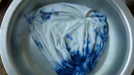 tie-dye fabric soaking in a basin