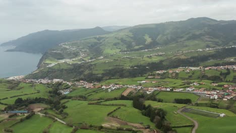 track back aerial drone from miradouro do pôr-do-sol over povoacao, sao miguel, portugal