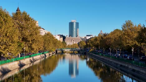 Filmische-Luftaufnahme-über-Den-Fluss-Dambovita-Mit-Einem-Bürogebäude-Im-Hintergrund,-Stadtteil-Izvor,-Bukarest