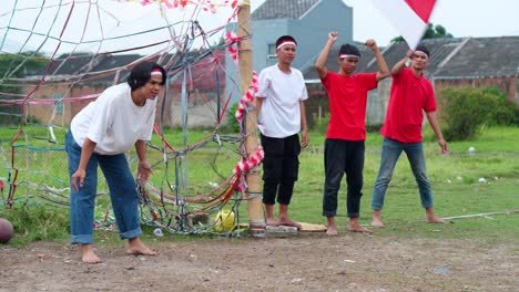 friends with red and white headbands cheering and raise their hands supporting playing soccer during the independence day festivities