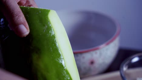 using a peeler to peel green skin from green and ripe yellow organic fresh papaya pawpaw