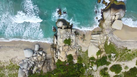 rocky beach and turquoise water in tropical coastal area in aerial downwards shot