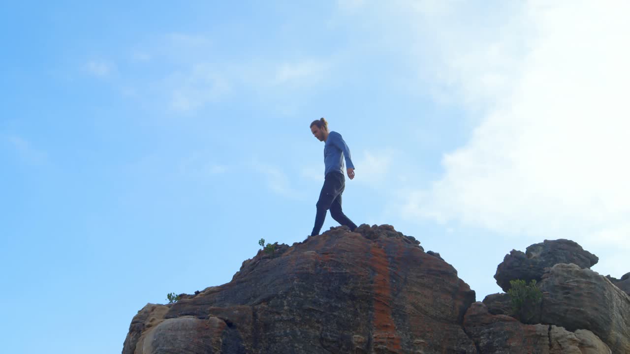 바위산 꼭대기에 서 있는 남성 하이커 4k
