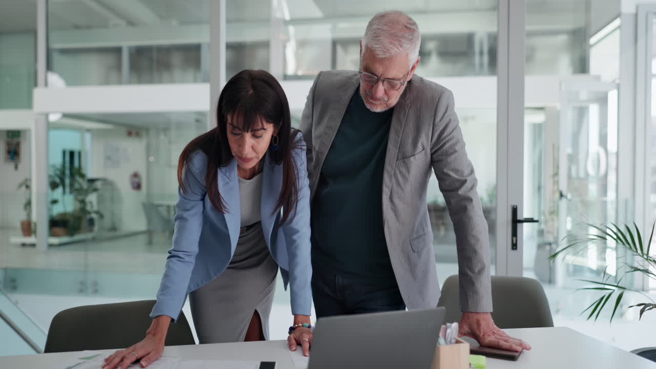 Business Colleagues Discussing Project Data on Laptop in Modern Office