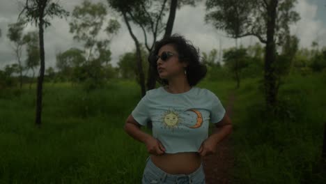 A-young-Indian-woman-stands-amid-the-lush-greenery-forest