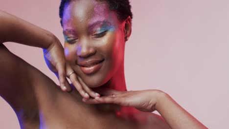 Happy-african-american-woman-with-short-hair-in-blue-and-pink-light-with-copy-space,-slow-motion