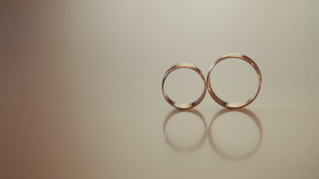 Wedding gold rings roll to each other. Close-up, macro shot