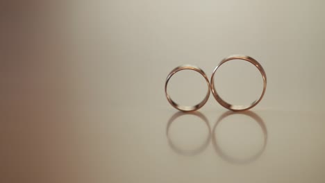 wedding gold rings roll to each other. close-up, macro shot