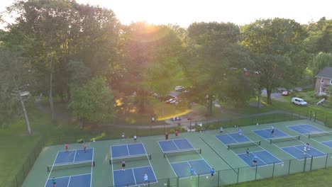 people playing pickleball in park during golden hour sunset