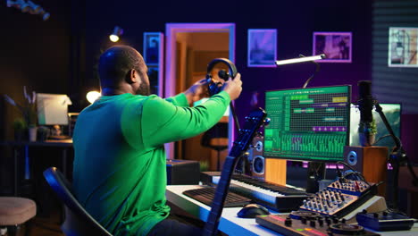 productor componiendo nueva música en un instrumento acústico en un estudio casero
