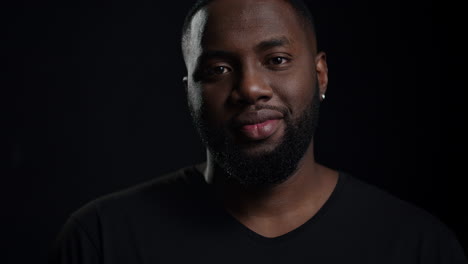 Relaxed-afro-guy-looking-at-camera-indoors.-Smiling-male-person-posing-in-studio