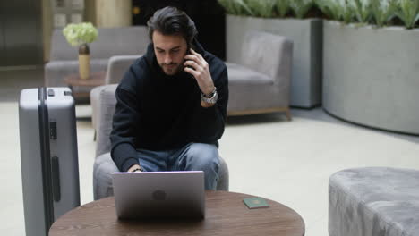 Un-Joven-Hablando-Por-Teléfono-En-El-Vestíbulo-Del-Hotel.