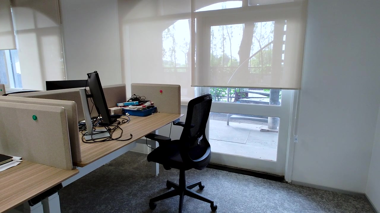 Estação de trabalho de escritório moderna e iluminada com computador de mesa, cadeira ergonômica e vista da janela. Perfeito para negócios, trabalho híbrido, produtividade no escritório, ambiente de trabalho e conceitos de interiores corporativos