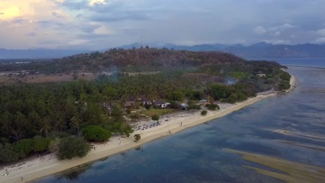 Chillen-Am-Strand-Unter-Palmen-Auf-Einer-Kleinen-Insel.-Sanfte-Luftaufnahme.-Flug-Vorwärts-Fliegen.-Sinkend.-Drohnenaufnahmen-Von-Gili-T-Bei-Sonnenuntergang.-Sommer-2017.-Filmische-Ansicht-Von-Oben-Von-Philipp-Marnitz