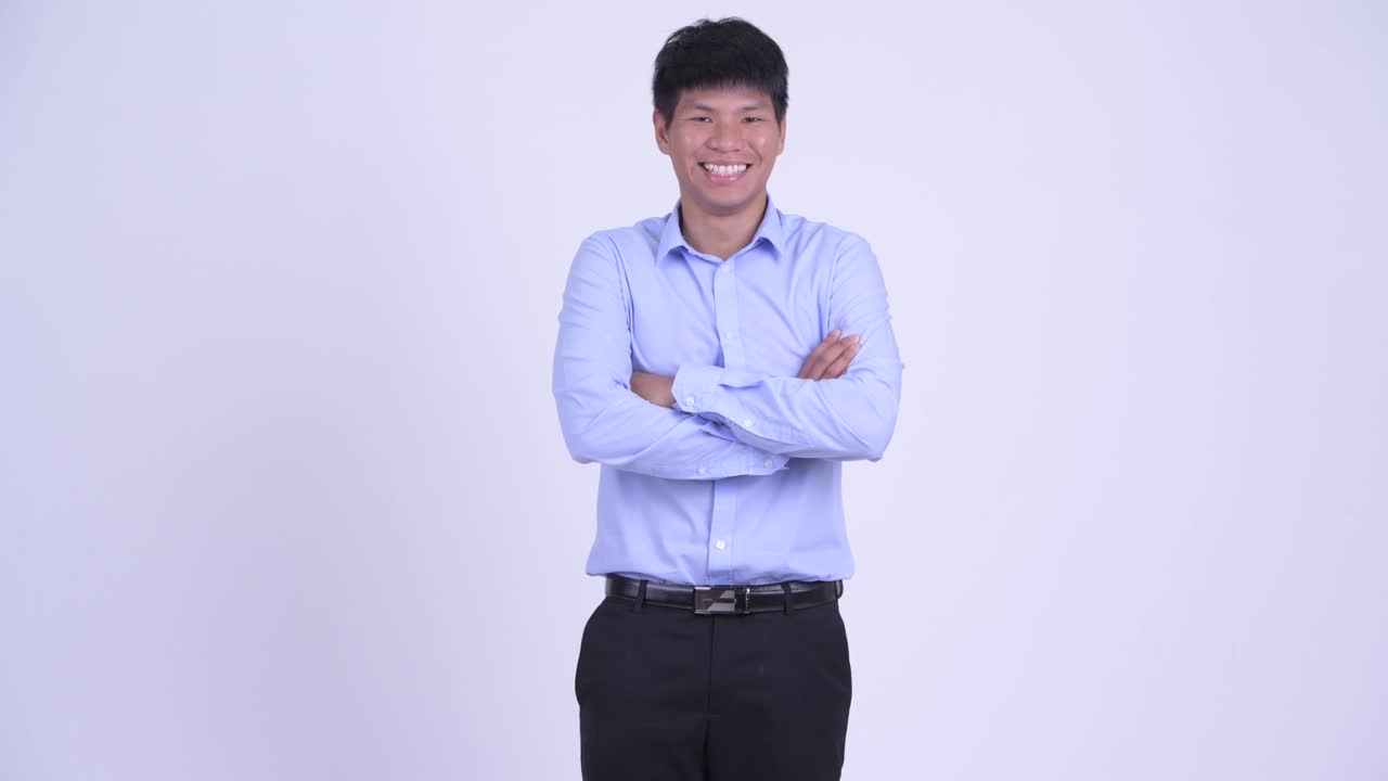 幸せなアジアの若いビジネスマンが腕を交わして微笑んでいる