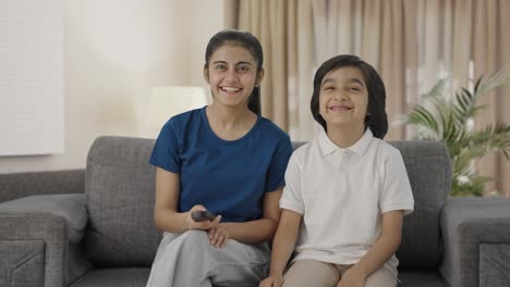 Indian-siblings-watching-TV-at-home-happily