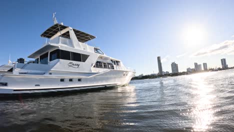 a yacht moves across the water near a city.