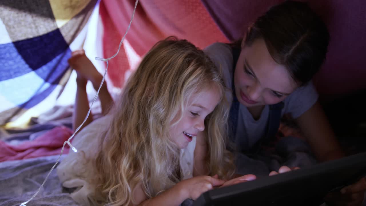 hermanas bajo sábanas formando una tienda