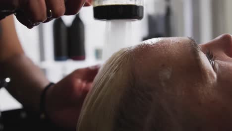 vista lateral de cerca mujer lavándose el cabello
