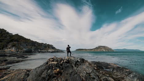 Man-Standing-On-Rocky-Hill-On-Shore-In-Tierra-Del-Fuego,-Patagonia,-Argentina