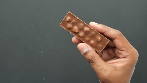 hand holding a chocolate bar with nuts