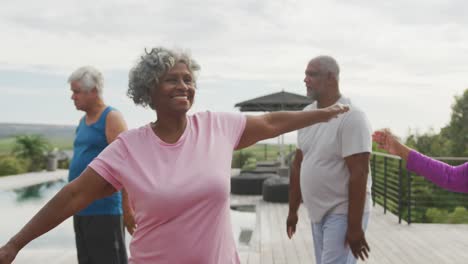 happy senior diverse people practicing yoga in garden at retirement home