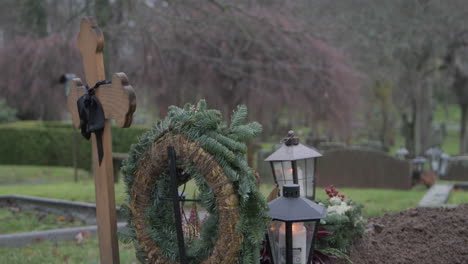 new wooden cross, lanterns and candles being lit on halloween in sweden