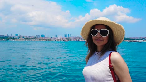 slow motion:beautiful girl stands in front of bosphorus,a popular destination in istanbul,turkey