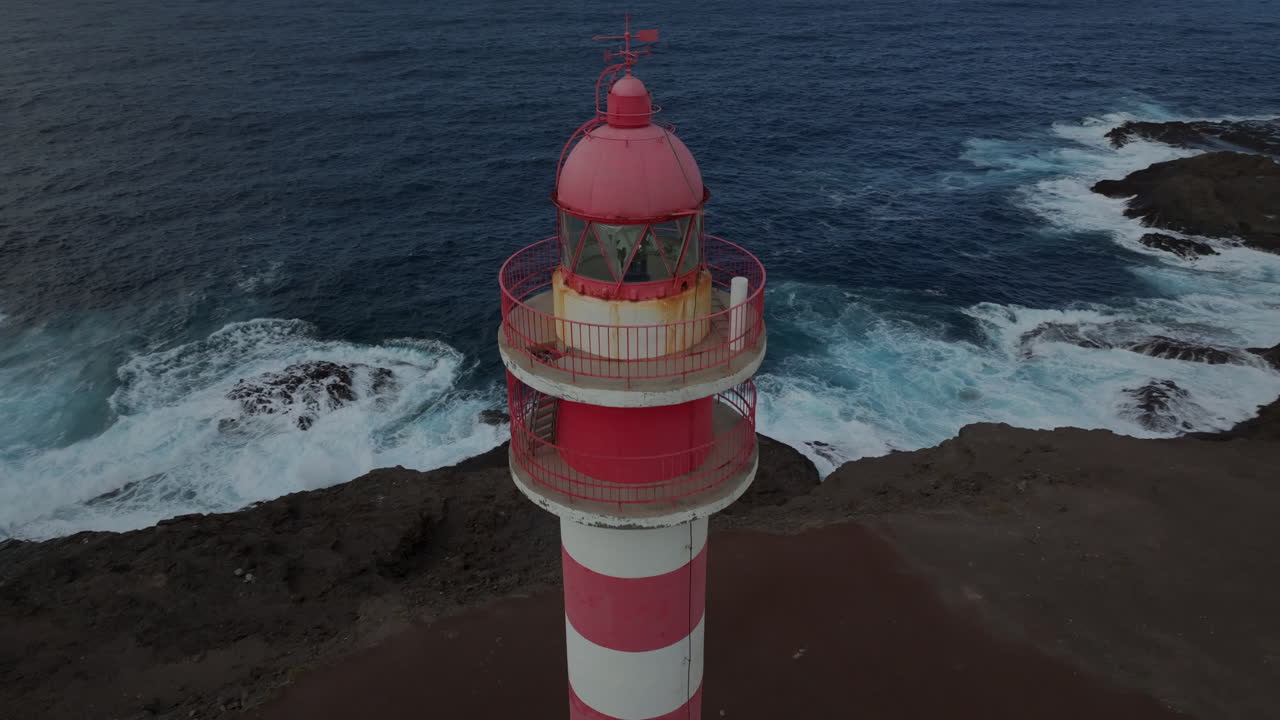 faro de la sardina: vista aérea en un círculo del faro y a poca distancia y donde se puede ver la costa y las olas golpeando