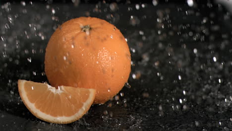 el agua llueve sobre las naranjas en súper cámara lenta.