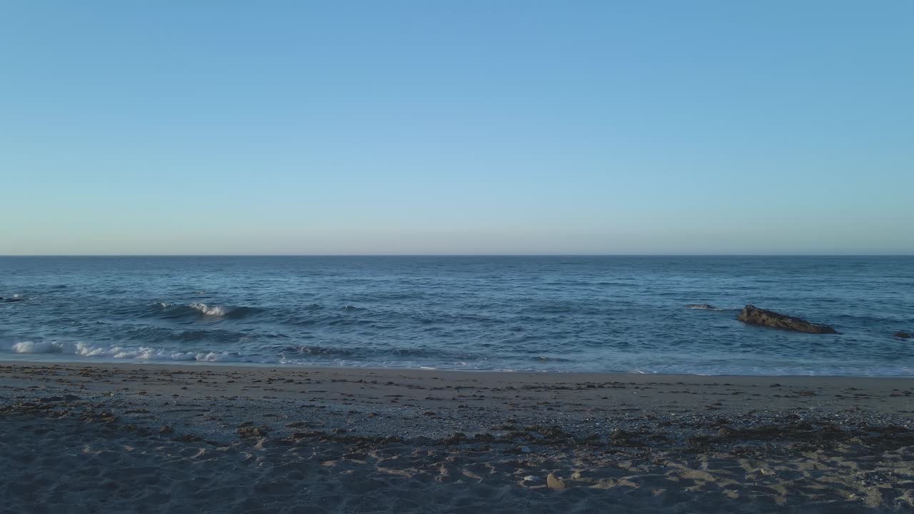 빈 해변에서 파도와 모래의 정적 샷