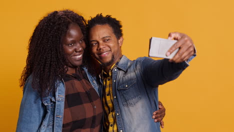 African-american-husband-and-wife-having-fun-taking-selfies-together-on-phone