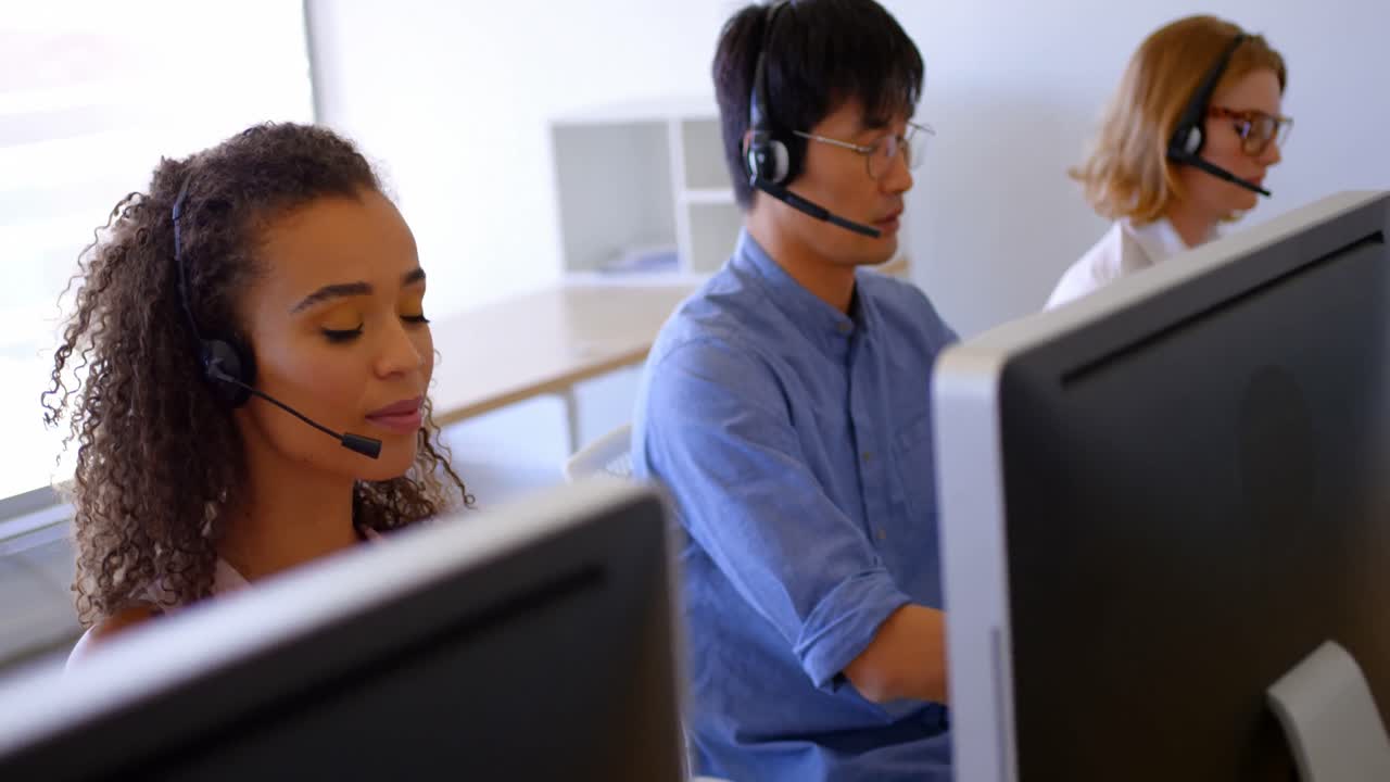 Multi-ethnic customer sales executives talking on headset in modern office 4k