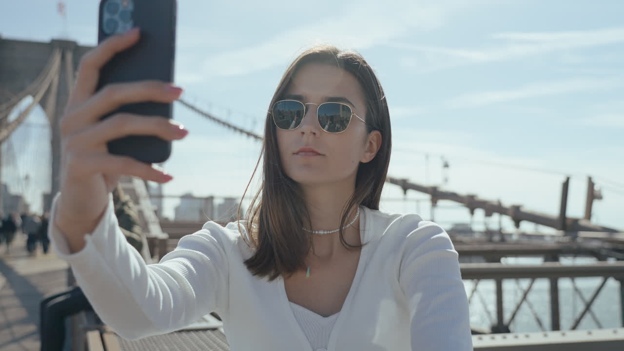 Woman taking selfie on Brooklyn Bridge