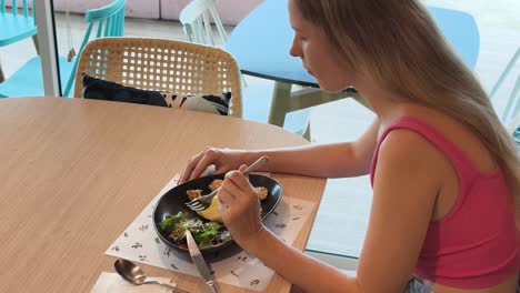 una mujer almorzando en un café.