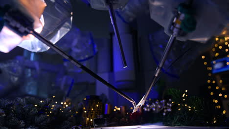 thin tiny forceps of robotic arms managing the writing pen to write a letter. side view. christmas decorations and lights at backdrop.