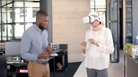 Using VR headset, woman interacting with virtual environment, man holding tablet