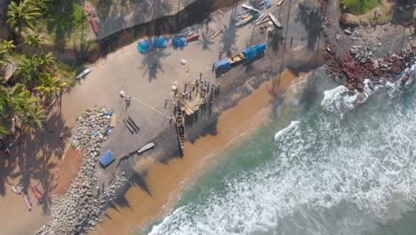 vista aérea en movimiento hacia adelante de los pescadores en la orilla, arreglando la red de pesca para pescar