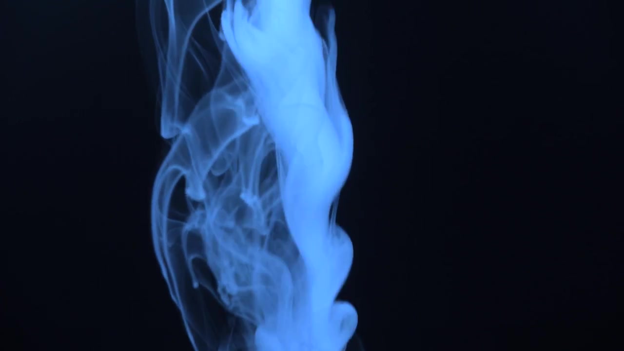 Fumo blu vorticoso in un ambiente scuro.