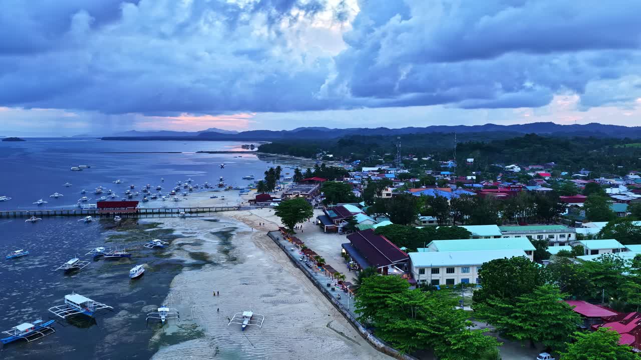 Langit berawan mendung di atas desa pesisir Poblacion V di Palawan