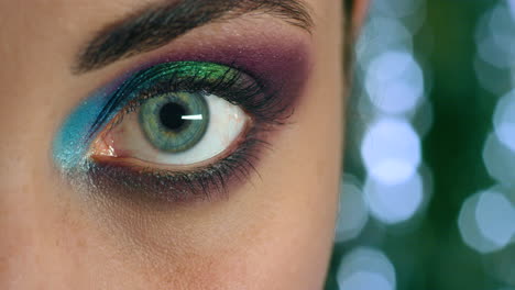 woman open eye, with colorful makeup on eyelid