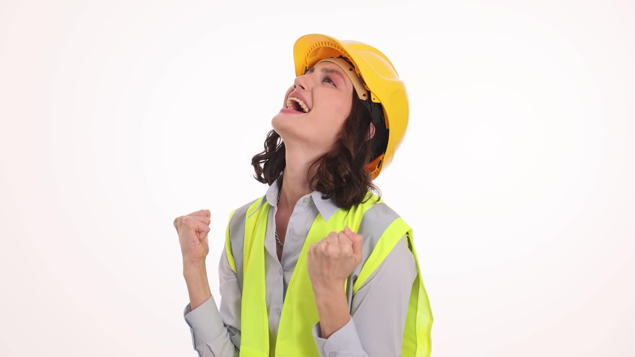 A female construction worker or engineer displays a range of strong emotions, from frustration to triumph, while wearing a hard hat and safety vest