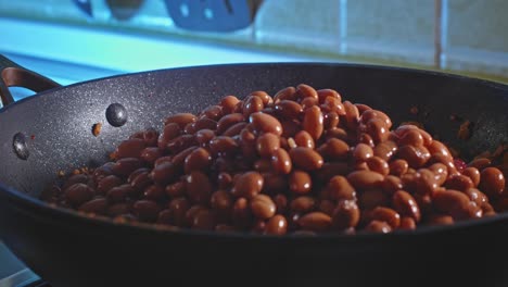 agregando frijoles enlatados al pavo molido cocinando en una sartén