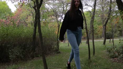 hot model with long legs walking amongst trees in a forest