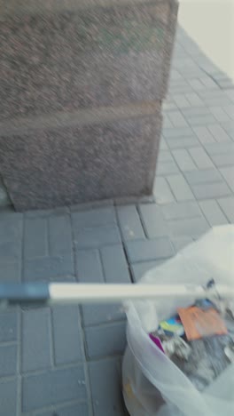 재활용통을 청소하는 도구를 사용하는 사람