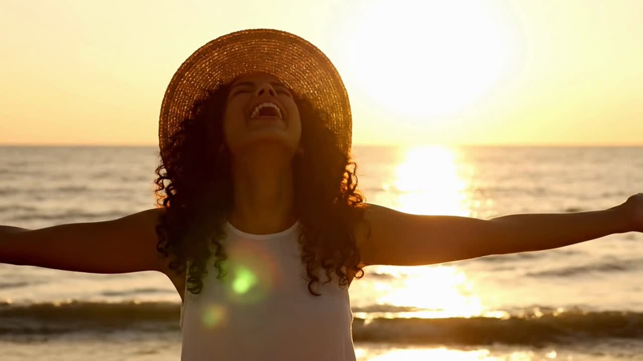 Happy laughing woman enjoying freedom at sunset beach